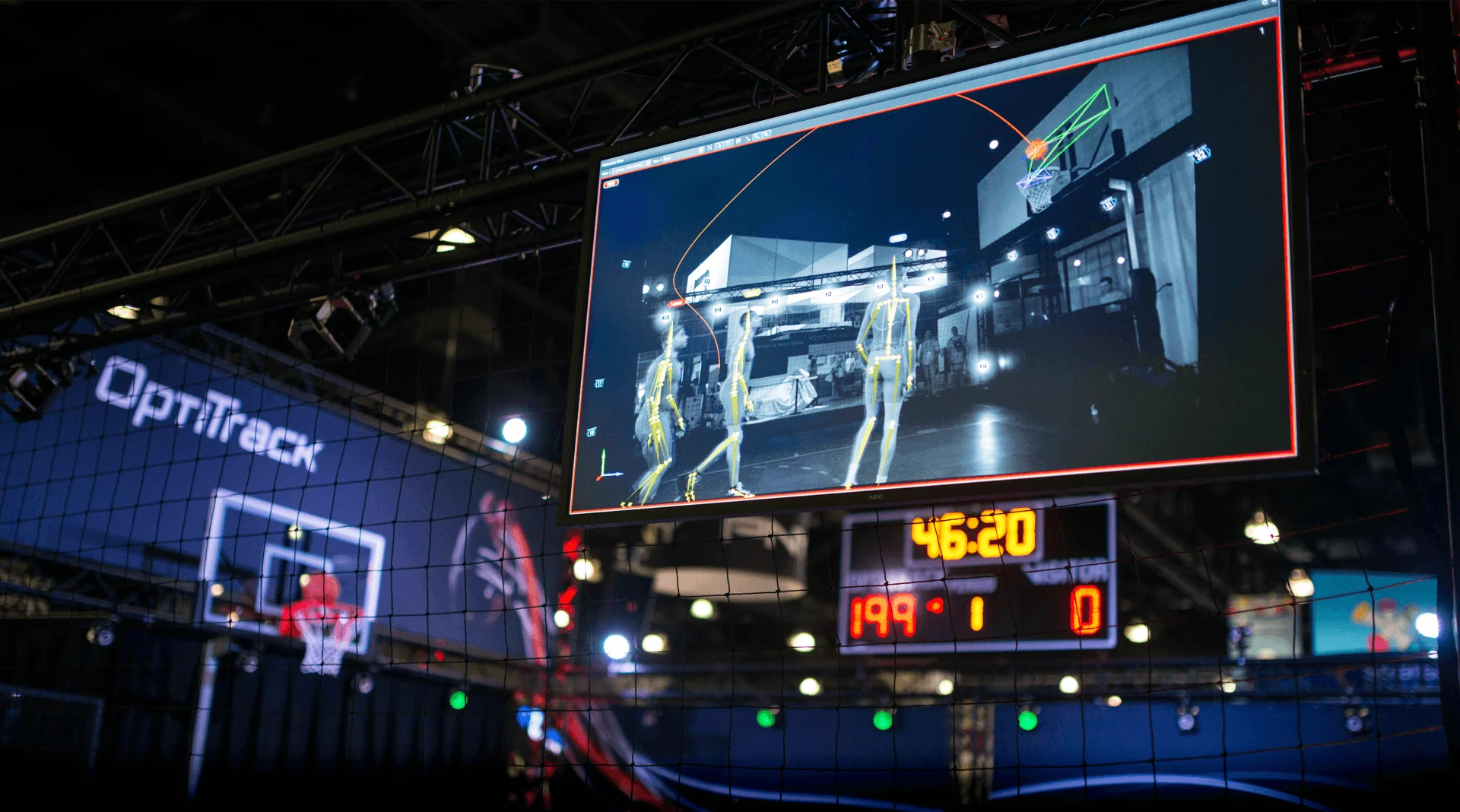 Computer screen in the forefront showing computer-generated people playing basketball with the actual environment where they are playing in the background