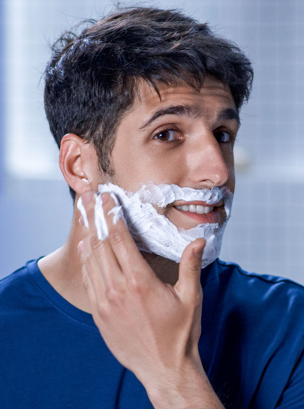 Afeitado, espuma en la barba y hombre con las manos en la cara, sonrisa y  colocación del producto en el estudio de maqueta. Crema de afeitado facial,  cabello y cuidado de la