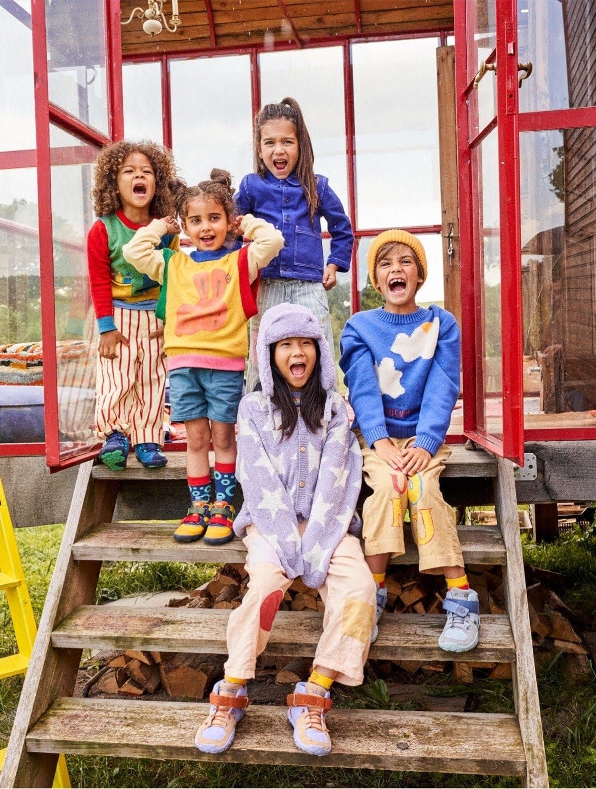 affenzahn-teaser-tile-produkttester-verschiedene-produkte-kindergarten-kinder-sitzen-auf-treppe-draussen