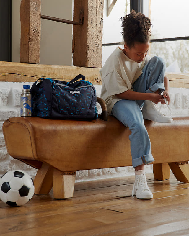 ergobag-hero-home-zubehoer-fuer-schulkinder-freizeit-kind-geht-zum-fussball-xs