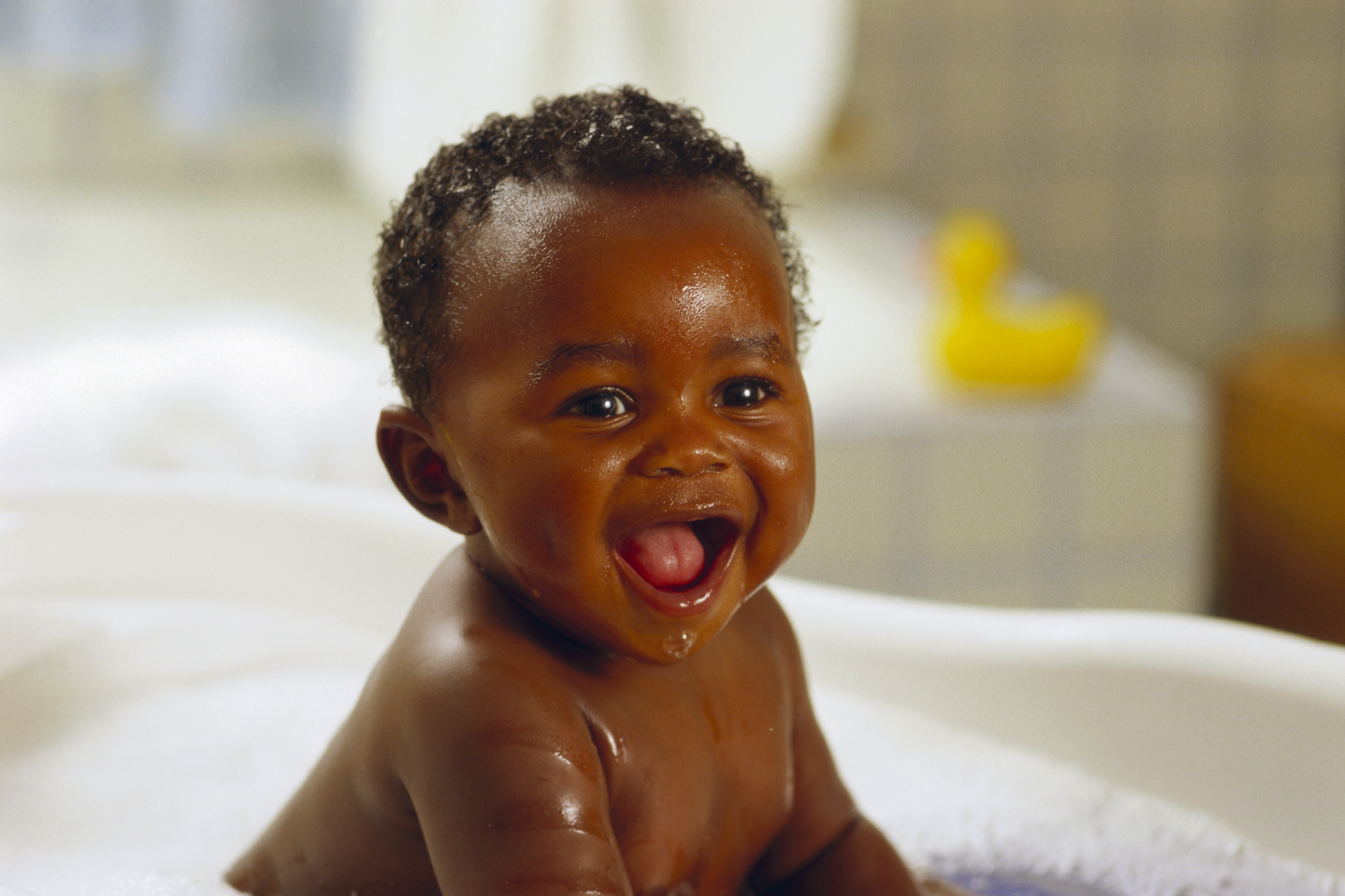 Toddler getting a bubble bath and smiling