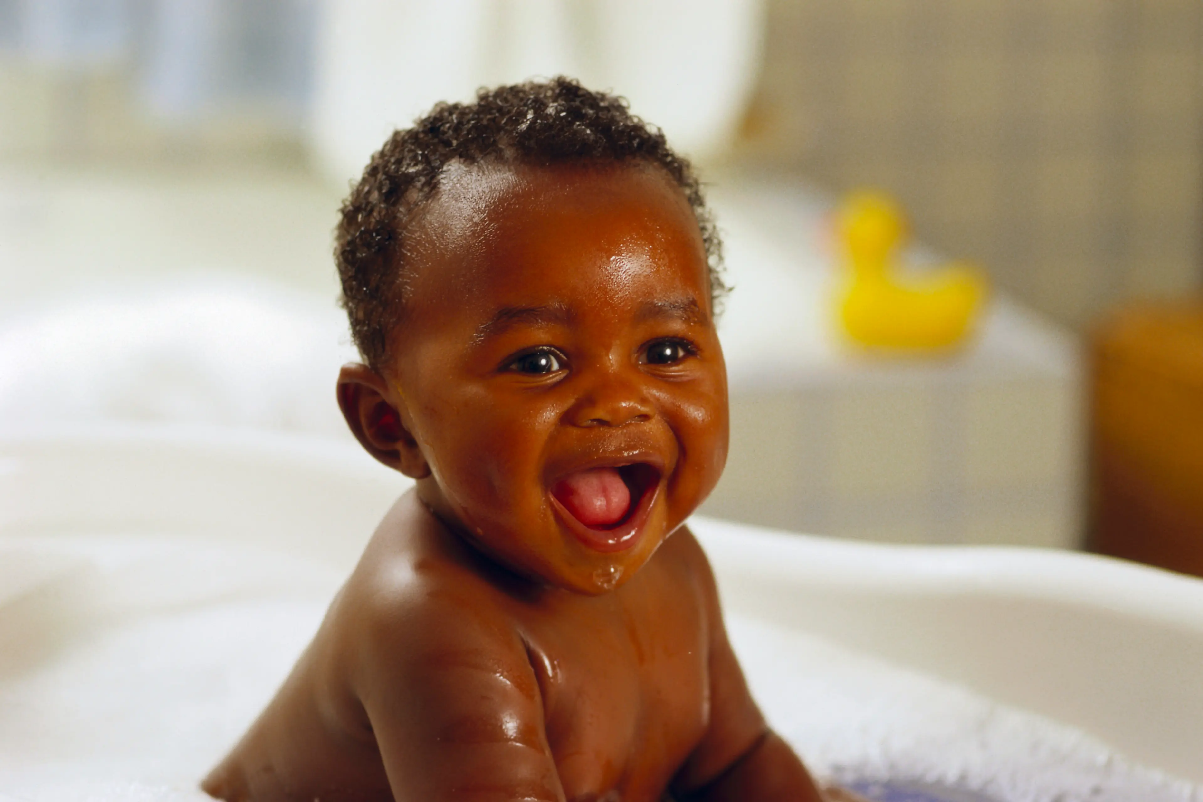 Toddler getting a bubble bath and smiling
