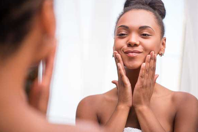 Femme souriante qui touche son visage