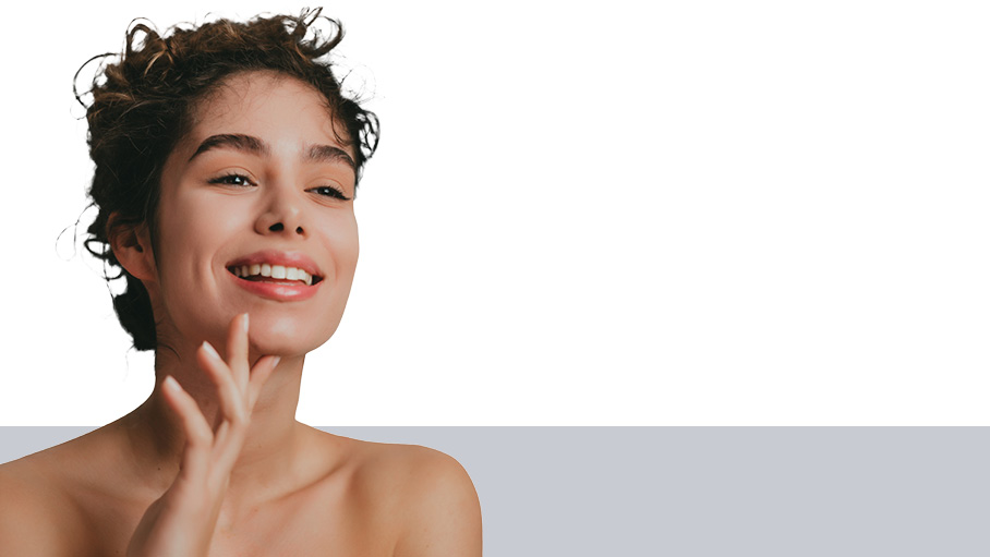 Young woman with curly hair holding her chin with her left hand and smiling