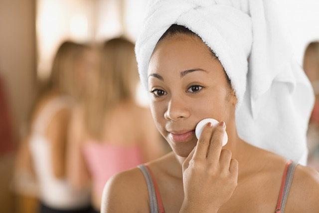 Femme qui enlève son maquillage avec un démaquillant NEUTROGENA® et un coton