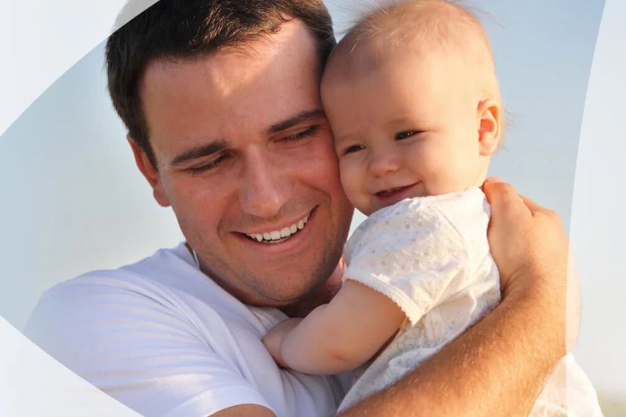 Father happily hugging a smiling baby