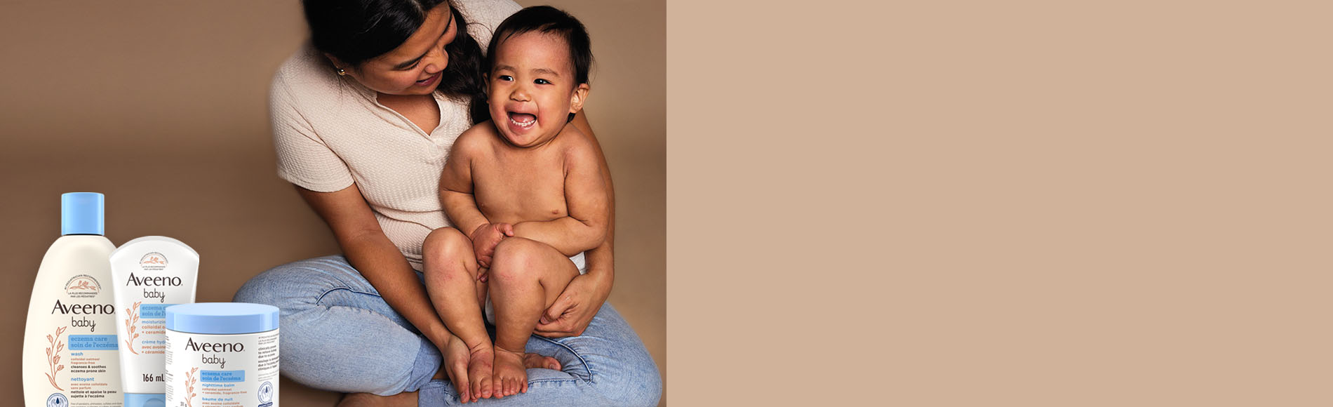 Une femme tenant son bébé souriant. Trois produits Soin de l’eczéma pour bébés : nettoyant Soin de l’eczéma, baume de nuit Soin de l’eczéma, crème hydratante Soin de l’eczéma