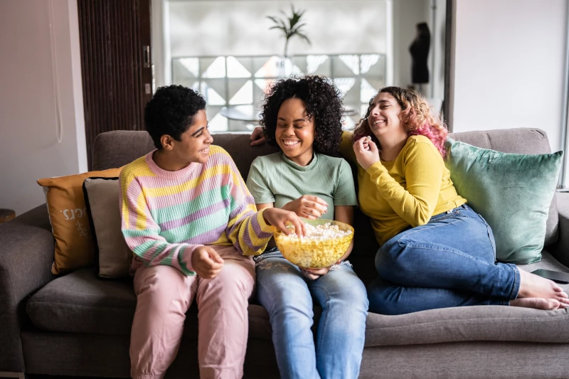 Group of friends sitting on a couch and laughing