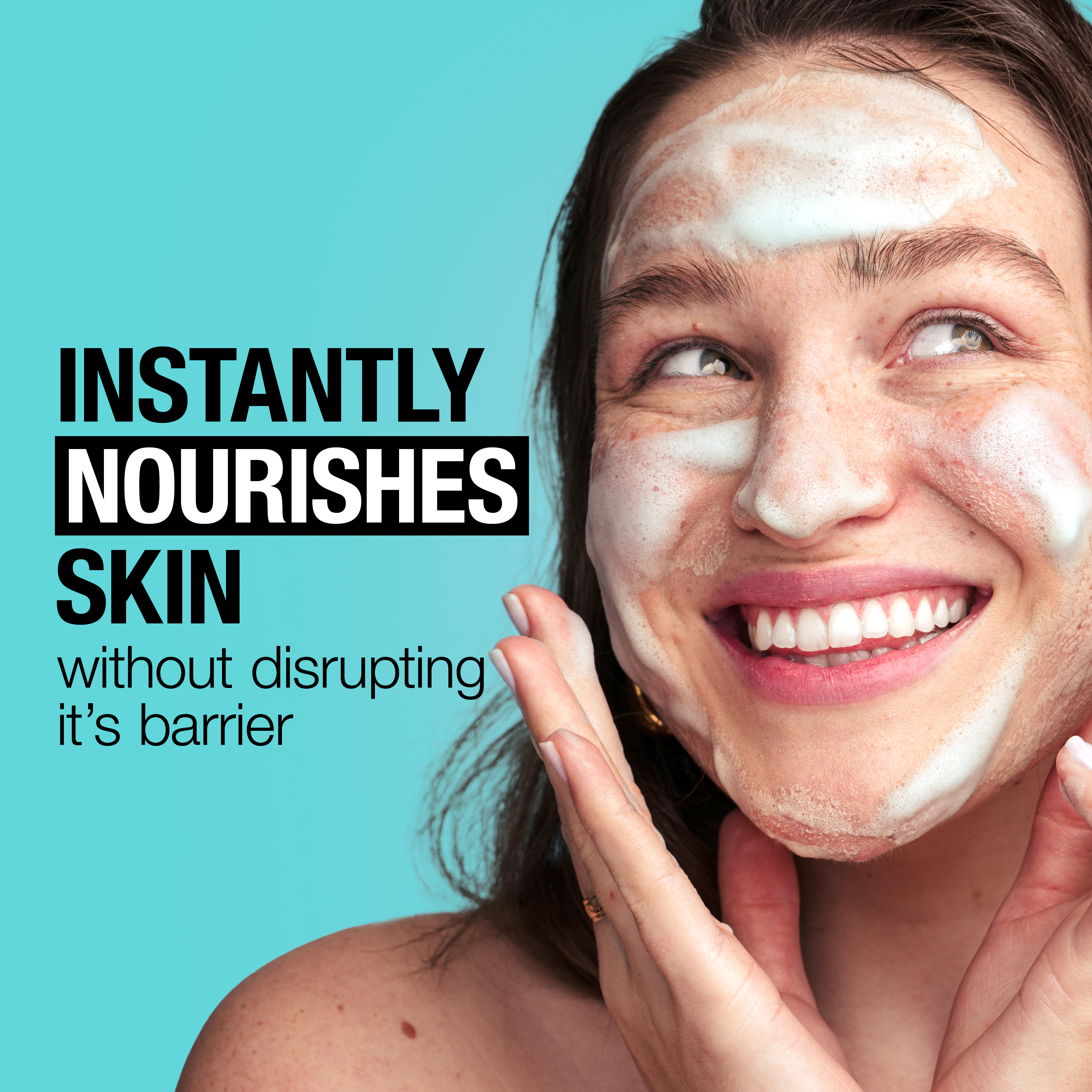 Young woman washing her face with a foaming cleanser while smiling