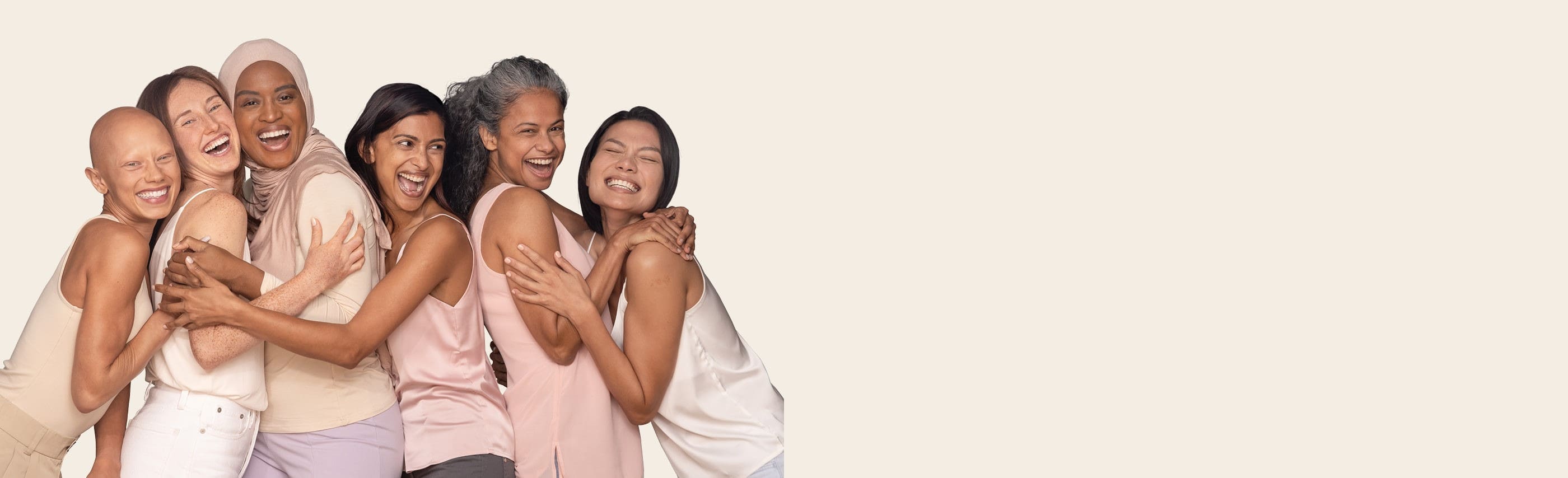 Six women from different ethnicities standing and holding each other and smiling