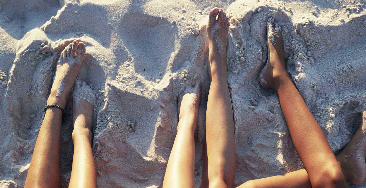 Jambes de plusieurs personnes sur la plage