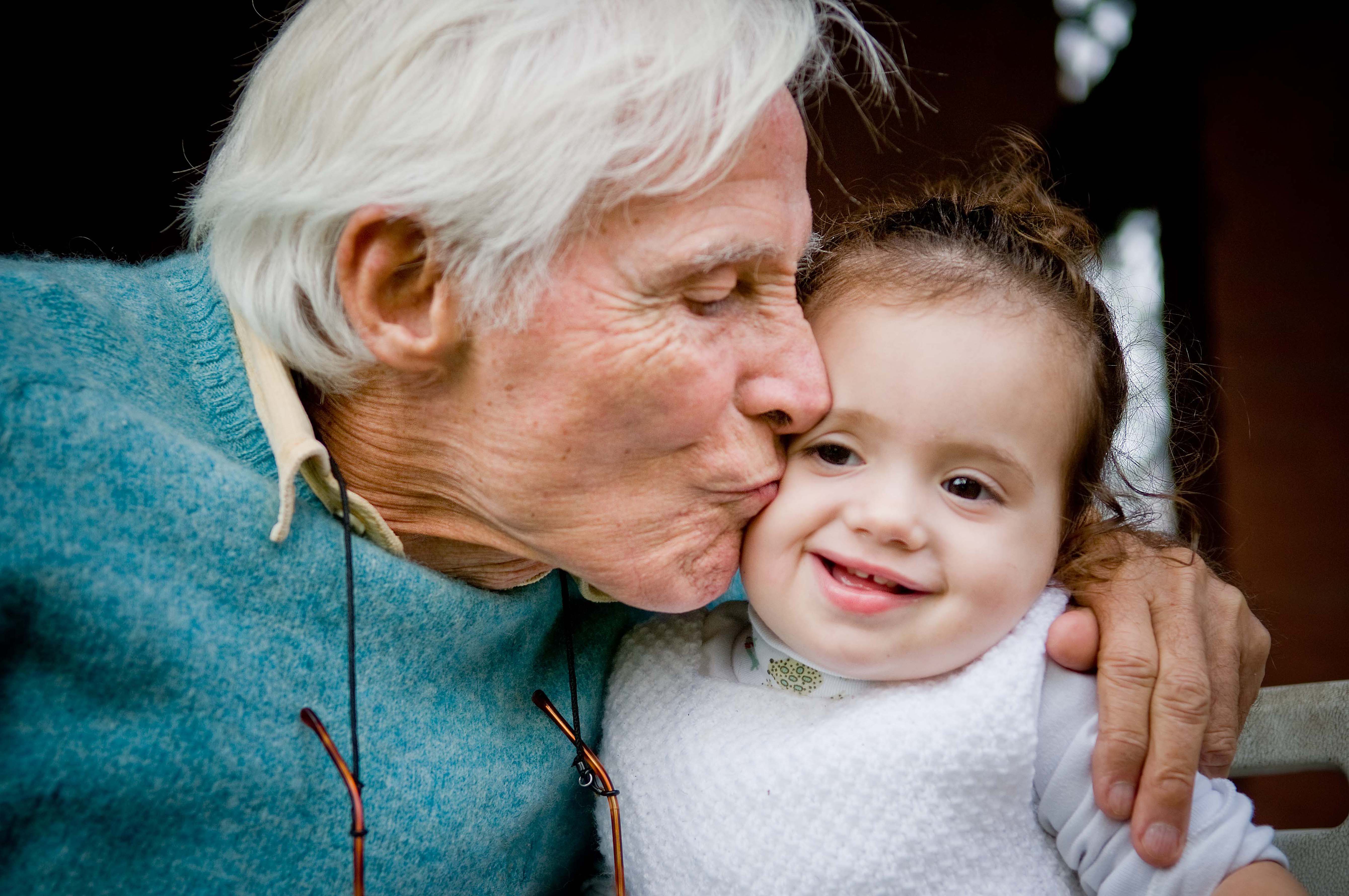A grandfather kissing his grandchild on the cheek