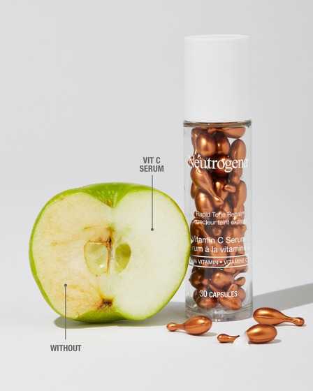 A bottle of NEUTROGENA® Rapid Tone Repair 20% Vitamin C Serum Capsules, 30ct and an experiment of vitamin C serum on an apple