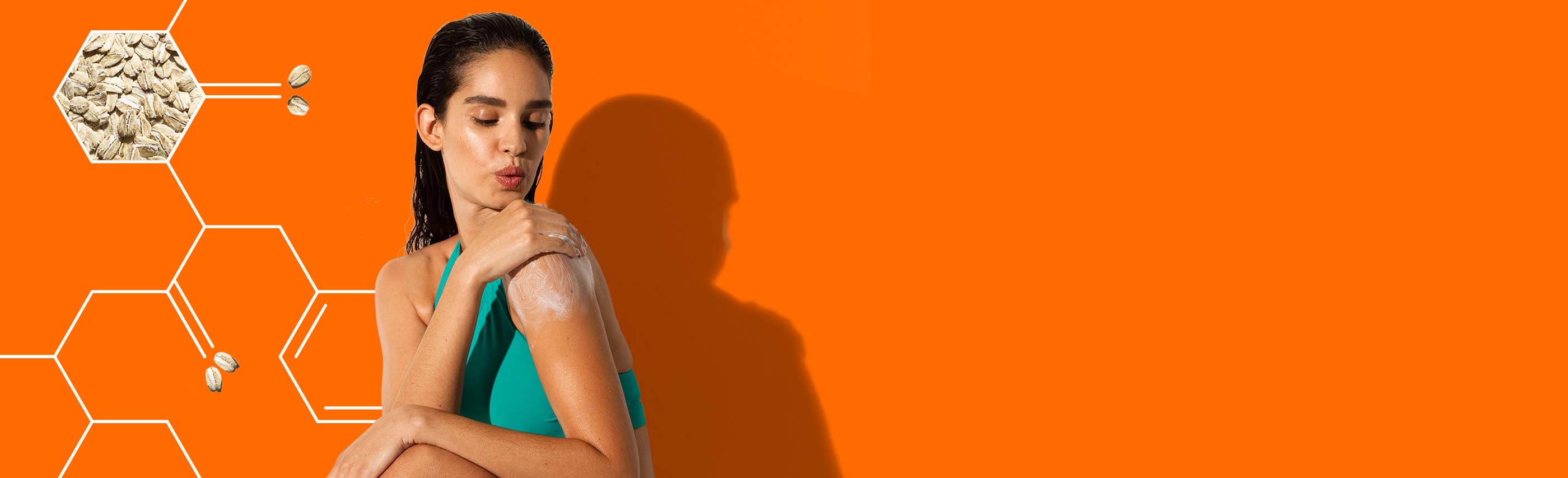 woman putting aveeno lotion on her shoulder against a bright orange background