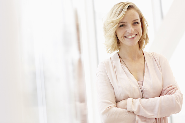 Femme souriante debout, les bras croisés