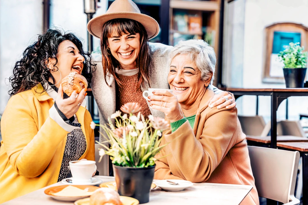 Three women enjoying pastries and coffee together