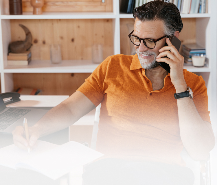Man siting at desk writing on paper
