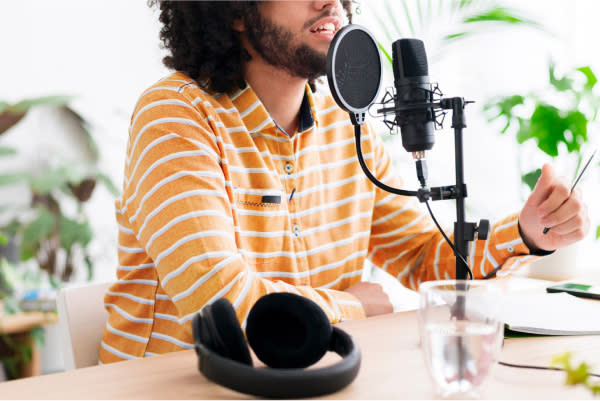 man siting at a microphone with headphones on the table