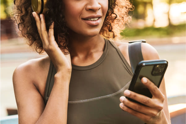 Women listening on headphones while looking at her phone