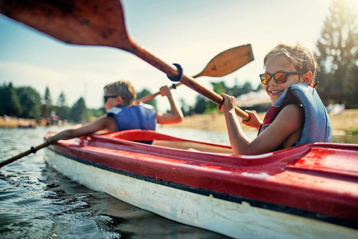 Two boys enjoying kayaking on lake Two boys enjoying kayaking on lake