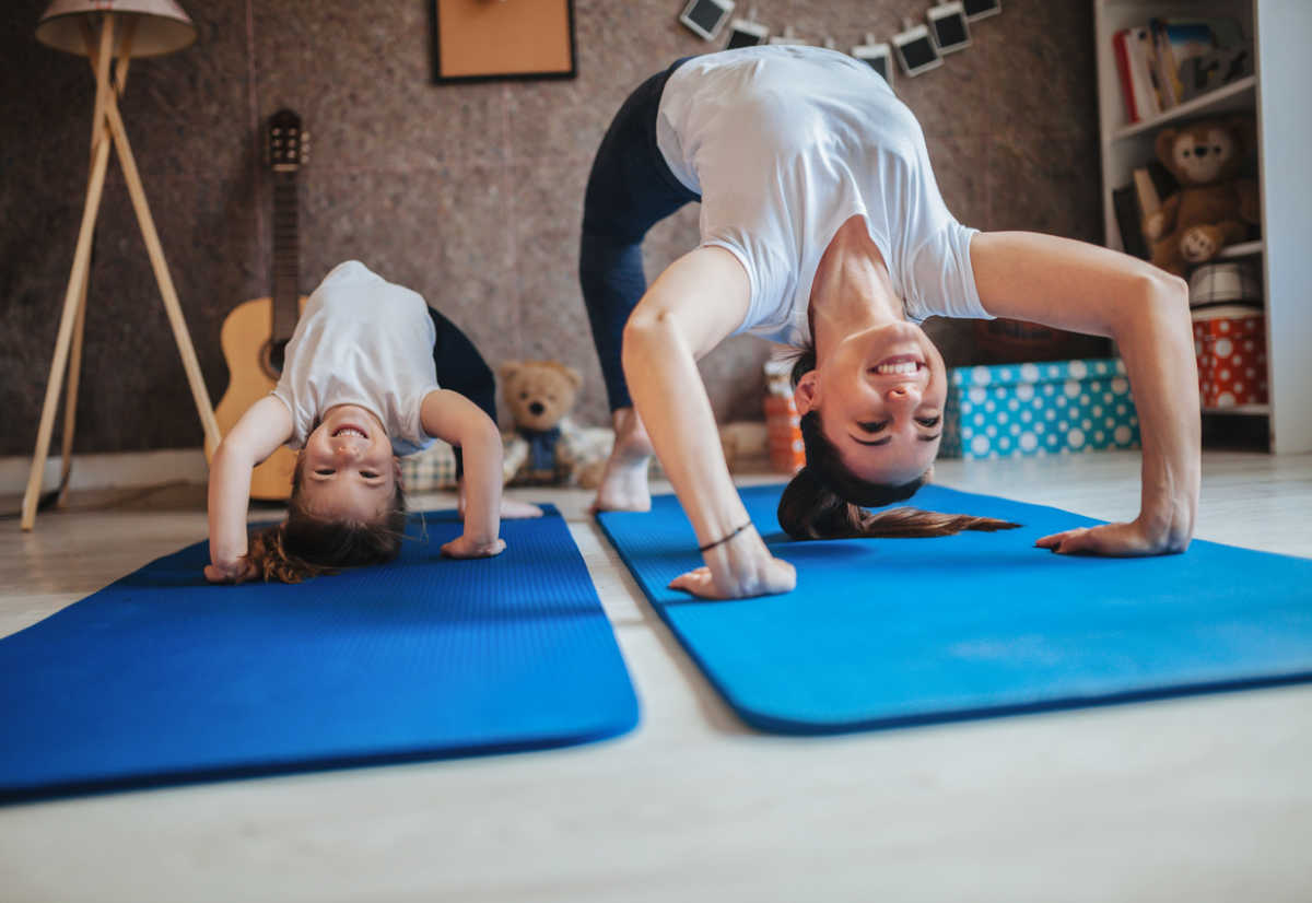 Mother and daughter working out together doing exercise at home