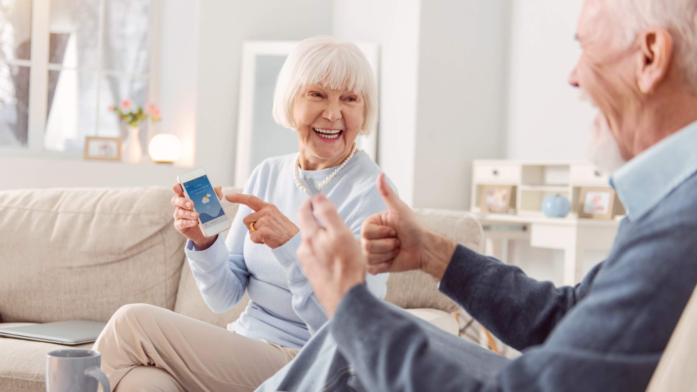 Seniorin zeigt ihrem Mann Apps für Senioren