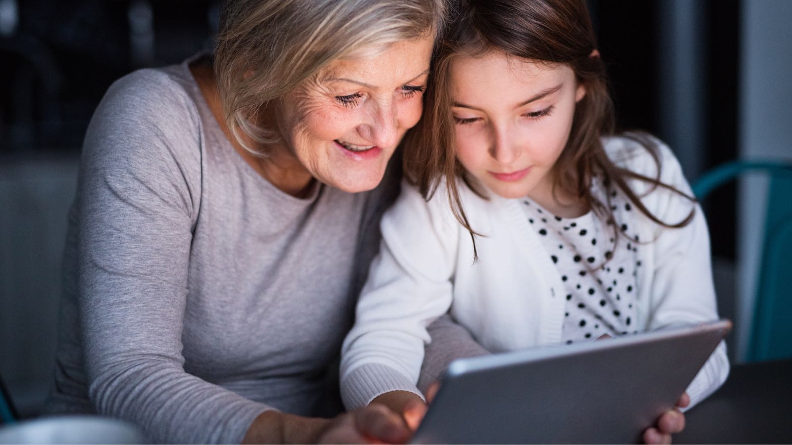 Eine Oma erfreut sich mit ihrem Enkelkind an einem Senioren Tablet