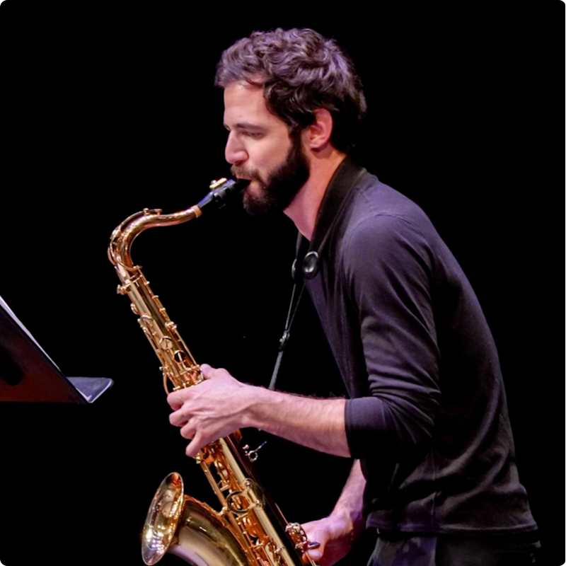 Danny playing the saxophone on stage. Image is modified to create a blue tint