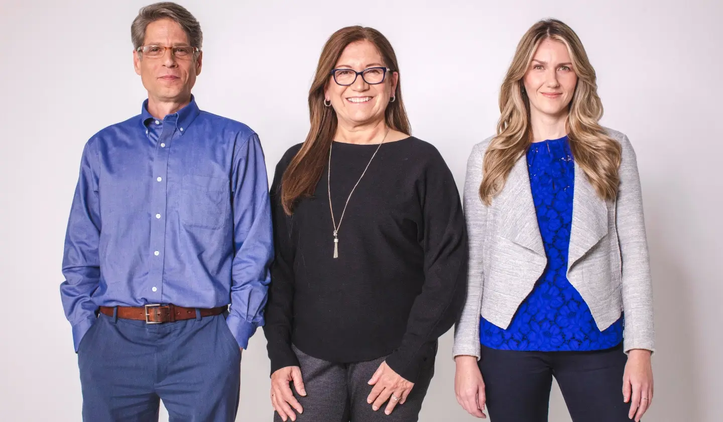 Three doctor posing for a photo with hands in pockets