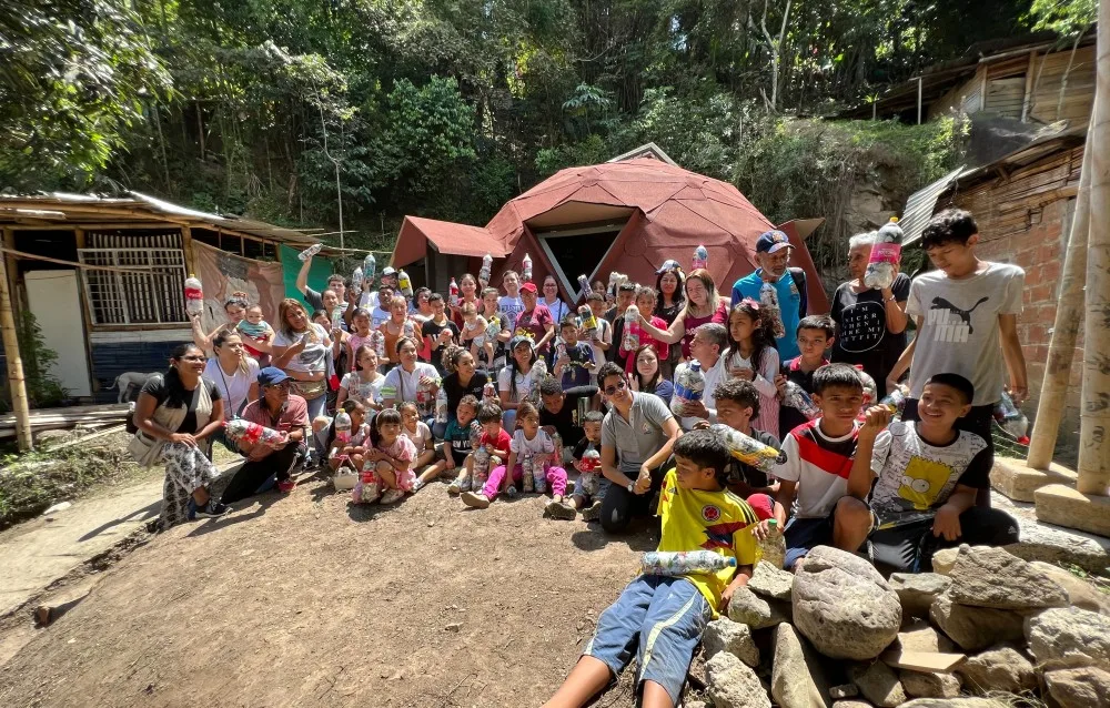 Community gathering at geodesic dome in forest setting