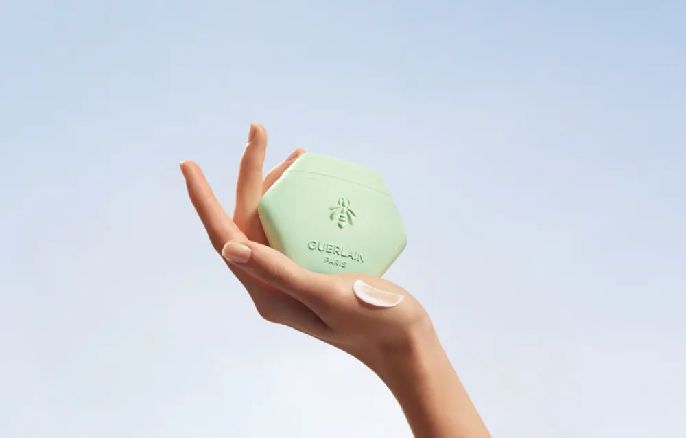 Hand holding Guerlain beauty product