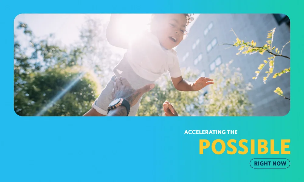 Child being lifted joyfully in sunlit park