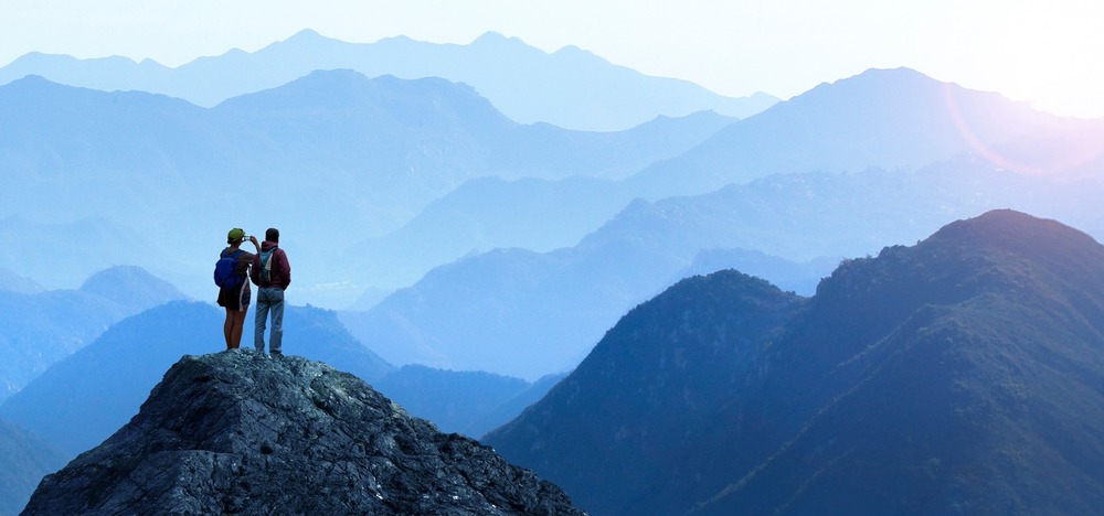 Mountain view in a landscape with 2 people in the foreground