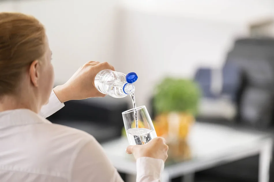 Person pouring water from bottle 