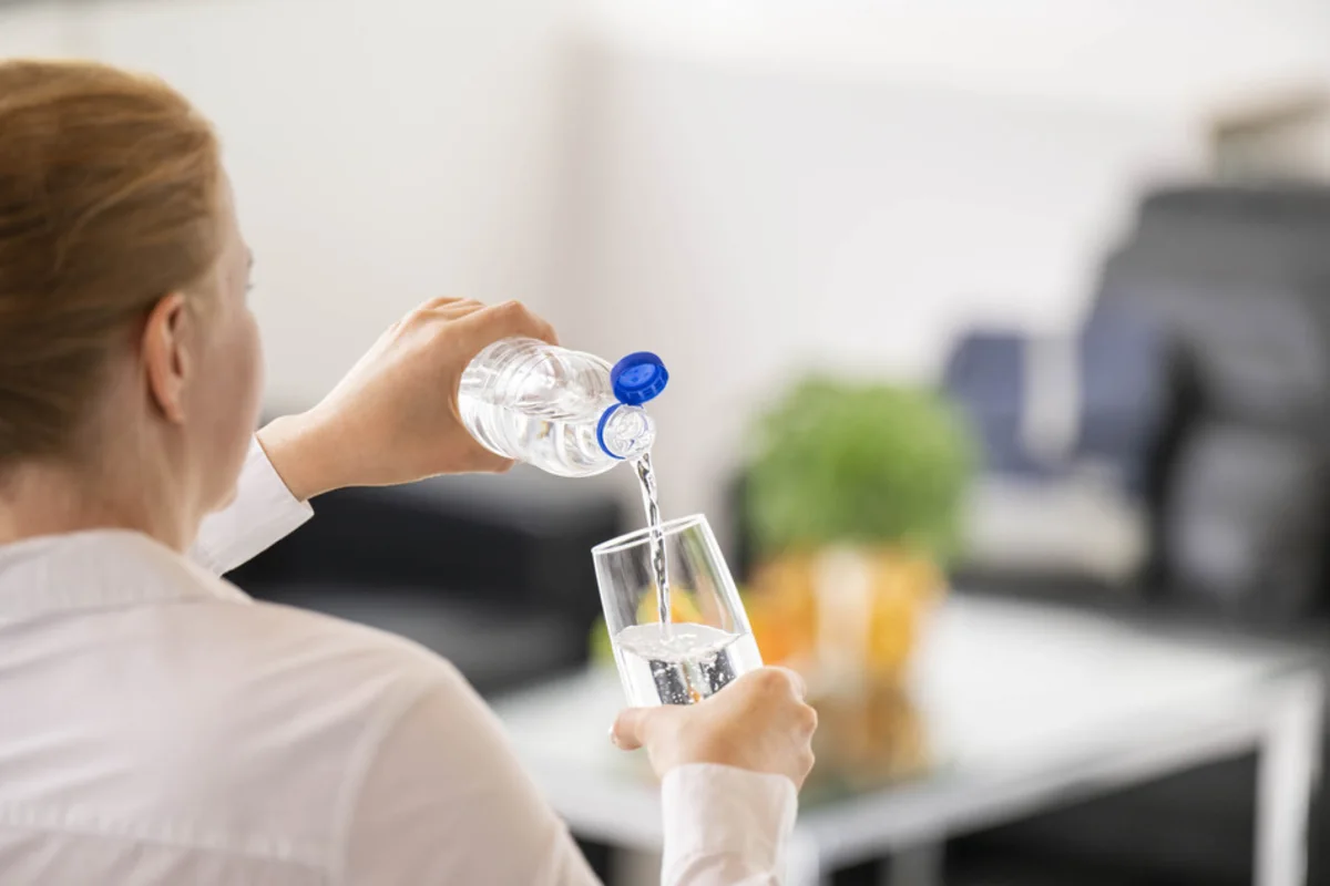 Person pouring water from bottle