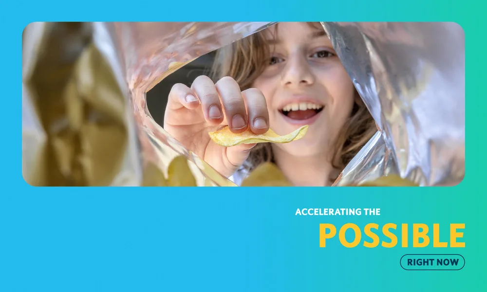 Child holding a potato chip through reflective packaging