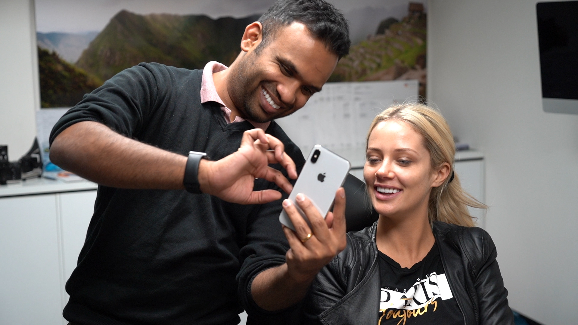 Dr Dee with Jessika Power looking at phone together at Vogue Dental Studios