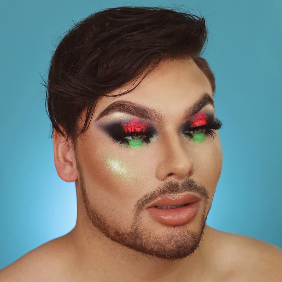 Michael Finch with red, green, and black eye shadow makeup look.
