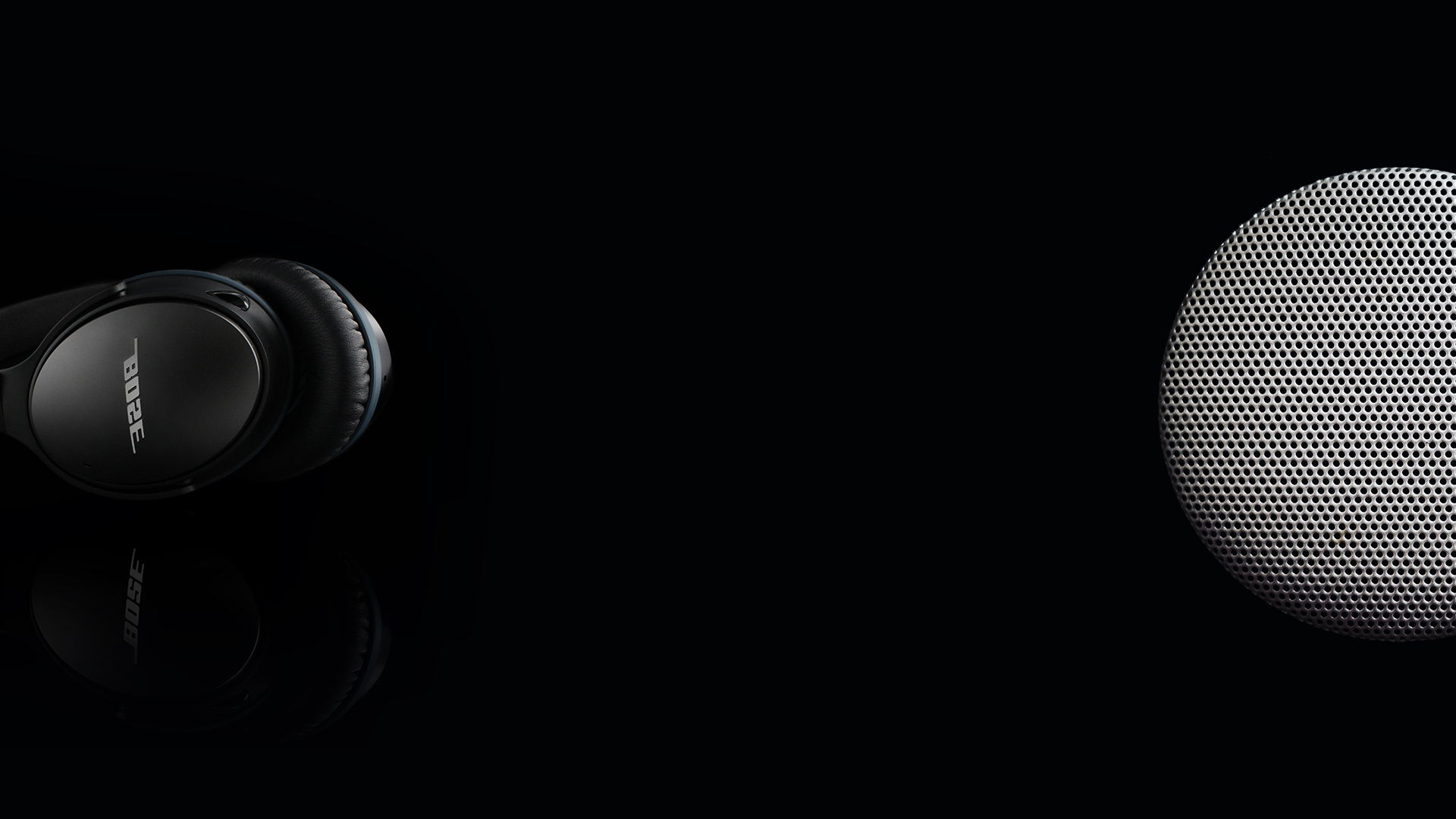 Bose headphones and speaker on black background.