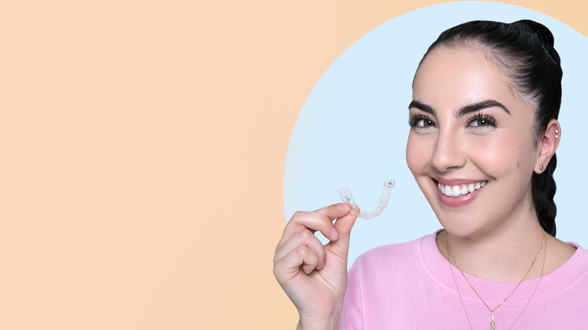 Emily holding her Invisalign clear aligners