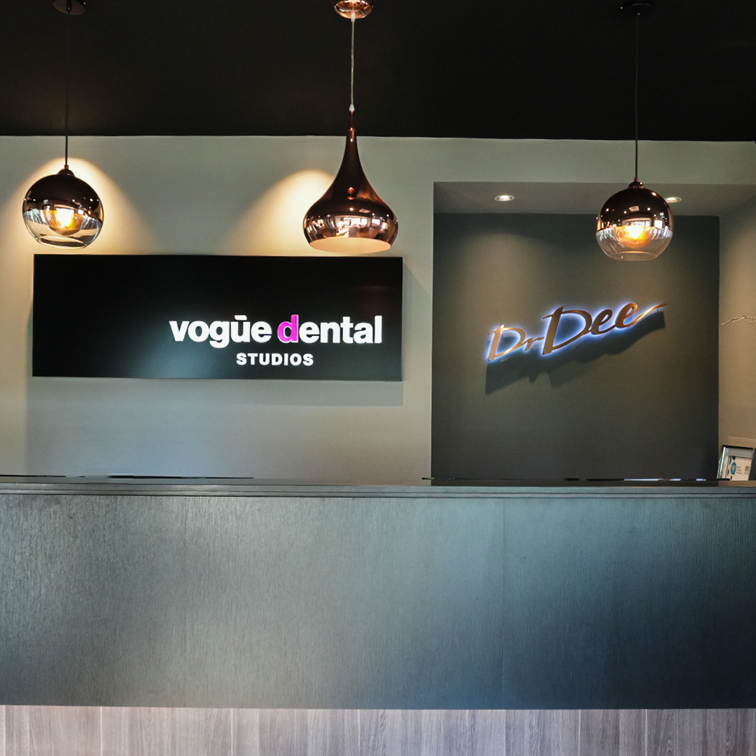 Vogue Dental Studios reception desk with rose gold pendant lights.