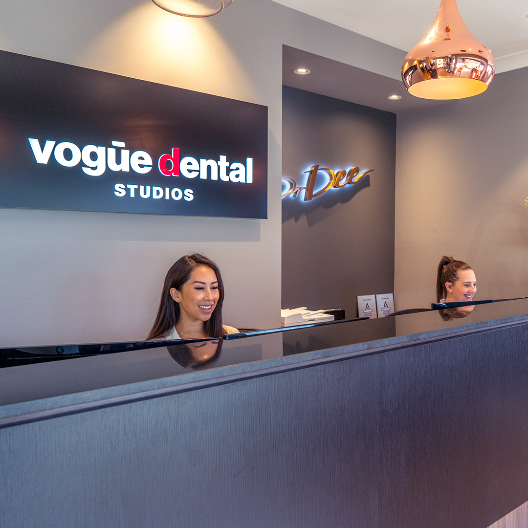 Vogue Dental Studios reception desk with rose gold pendant lights.
