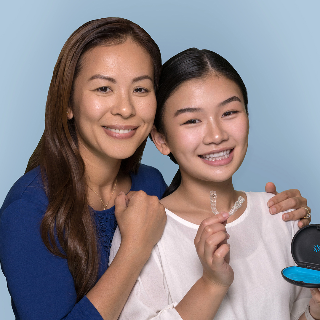 Mother and teen daughter embracing with Invisalign at Vogue Dental Studios.