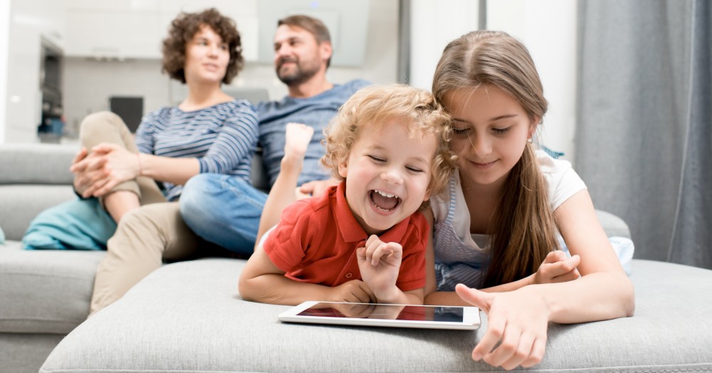 Familia con hijos viendo iPad