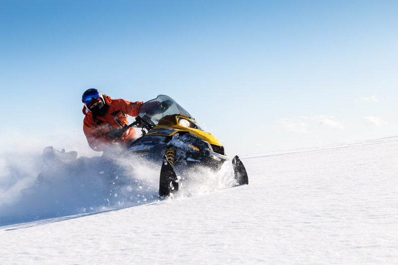 A person driving a snowmobile through snow