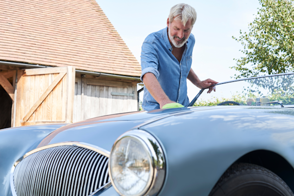 Mature man cleaning a classic sports car
