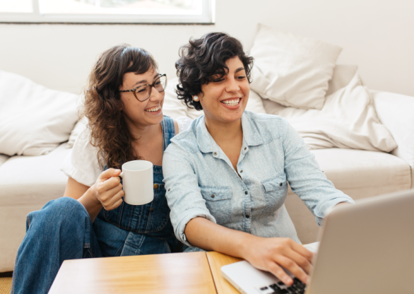 A female couple looking at a laptop and smiling