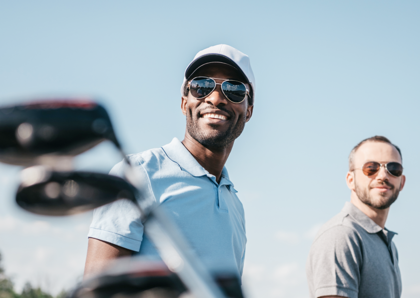 Two golfers smiling and looking off in the distance