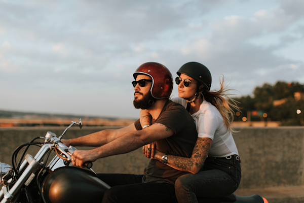 A young couple on a motorcycle together