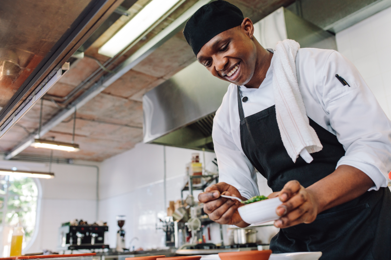 Gourmet chef in uniform cooking in a commercial kitchen